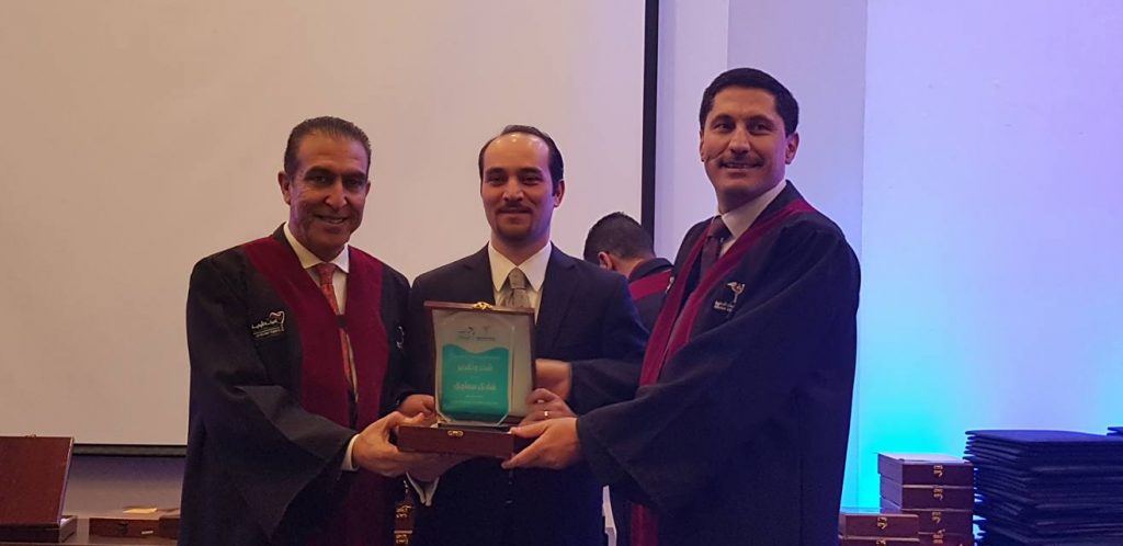 A formal presentation ceremony where a group of men in academic robes are exchanging an award or plaque.